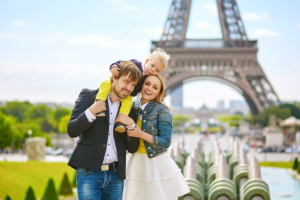 Happy family of three having fun together in Paris near the eiffel tower