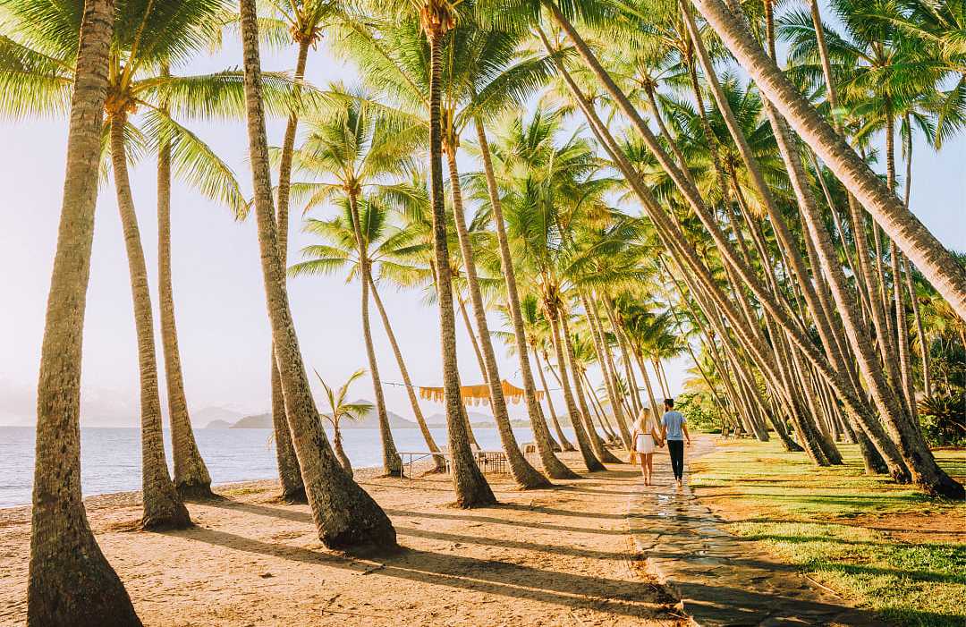 Palm Cove in Queensland, Australia.  Photo courtesy of Tourism and Events Queensland Coulple taking a romantic walk in Palm Cove in Queensland, Australia
