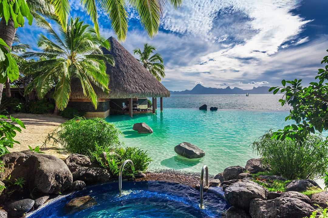 Infinity pool with jacuzzi over tropical ocean in Tahiti.