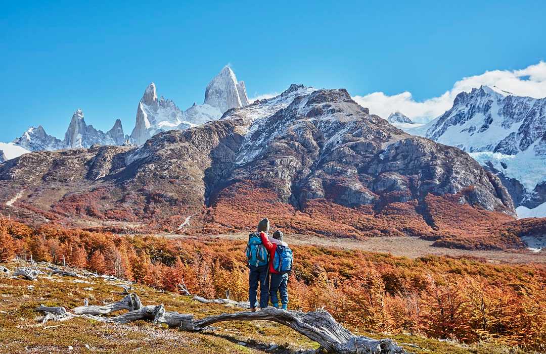 Brothers admiring the snowy peaks of Mount Fitz Roy, Patagonia, Argentina, during autumn