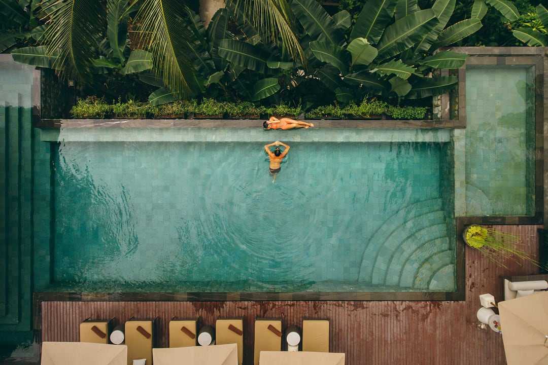 Tropical poolside retreat surrounded by lush greenery and serene vibes.