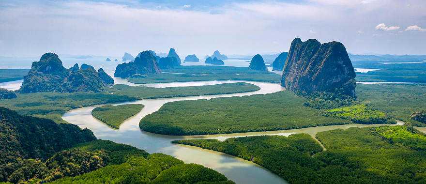 Aerial view of towering limestone cliffs and mangrove forest in Phang Nga Bay, Thailand.
