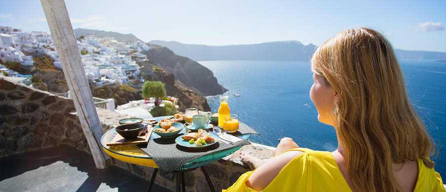 Traveler enjoying the view from private terrace in Santorini