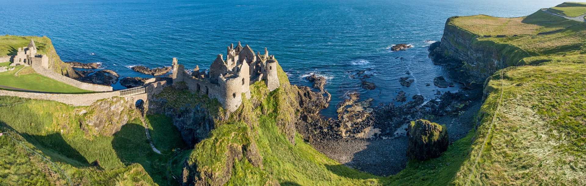 Ruins of medieval Dunluce Castle on a steep cliff on the northern coast of County Antrim, Northern Ireland, UK. 
