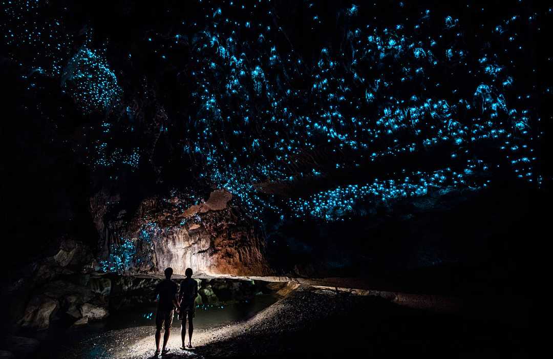 Glowworm Cave in Waitomo, New Zealand Couple inside the romantic glowworm cave in New Zealand