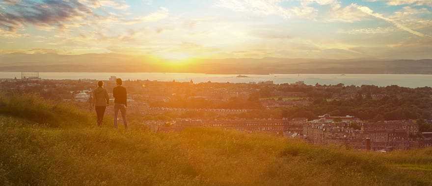 Couple enjoying cityscape at sunset, Edinburgh, Scotland, UK
