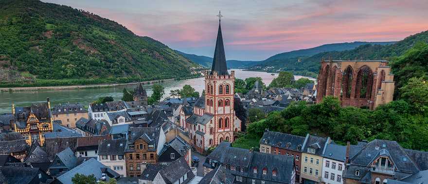 Parish Church of St. Peter surrounded by local homes and vineyards Bacharach, Germany during sunset.