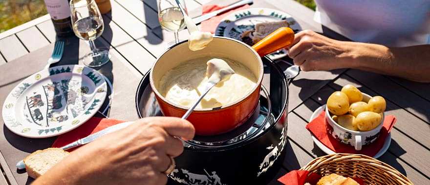 Two women enjoy a fondue on the Moleson in Gruyères, Switzerland