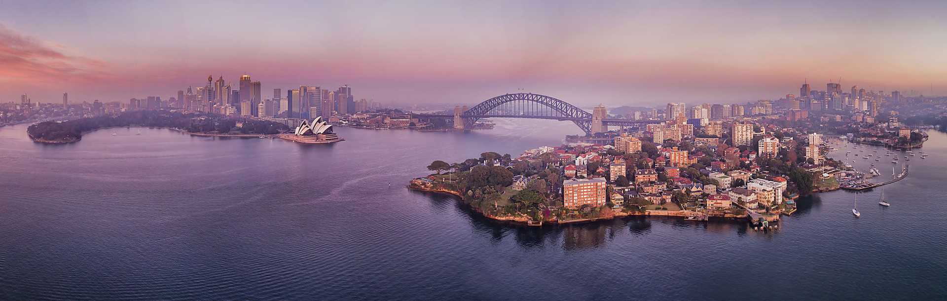 Pre-dawn sun light reflecting in waters of Sydney Harbour and bays around the waterfront of Sydney, Australia.