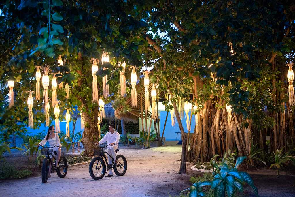 Couple fat biking around Fasmedhoo Island in the Maldives
