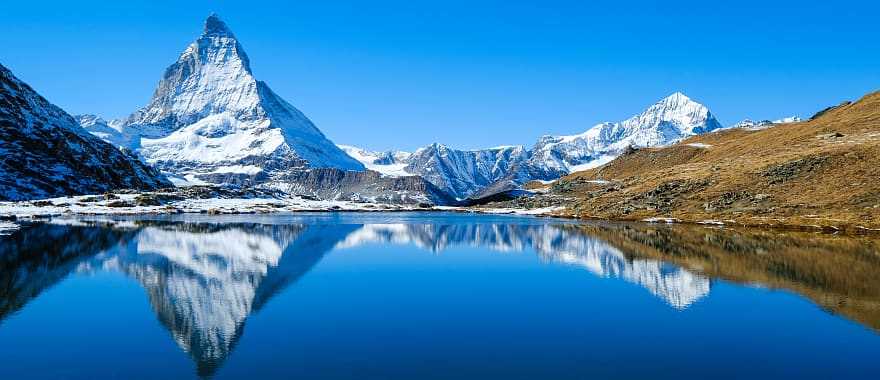 The Matterhorn summit is reflected in the glacial lake of the Swiss Alpine waters.
