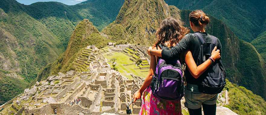 Couple looking at the lost city of the Incas, Machu Picchu in Peru