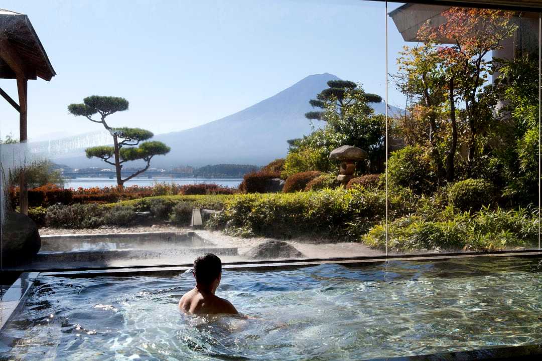 Man enjoying a luxury spa experience at Kawaguchi Lake and Mount Fuji in the background