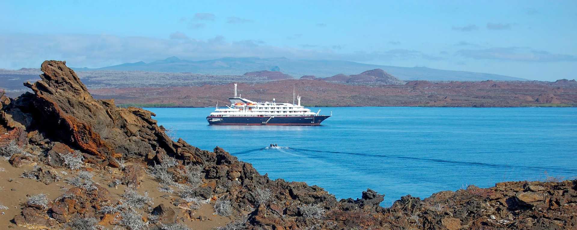 Volcanic landscape with cruise ship anchored in Sullivan bay at Santiago Island, Galapagos, Ecuador