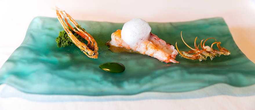 Whole prawn, charcoal-grilled king prawn, head juice with seaweeds, seawater and sponge cake of plankton served at El Celler de Can Roca, in Girona Spain