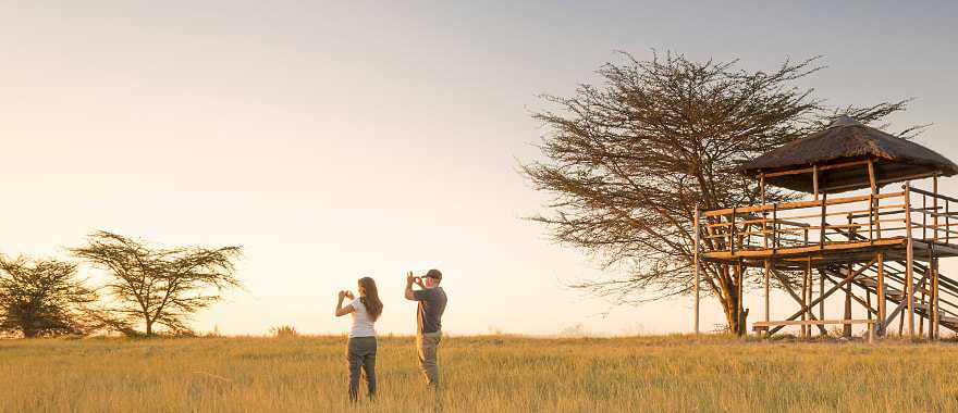 Couple taking photos on safari in Africa