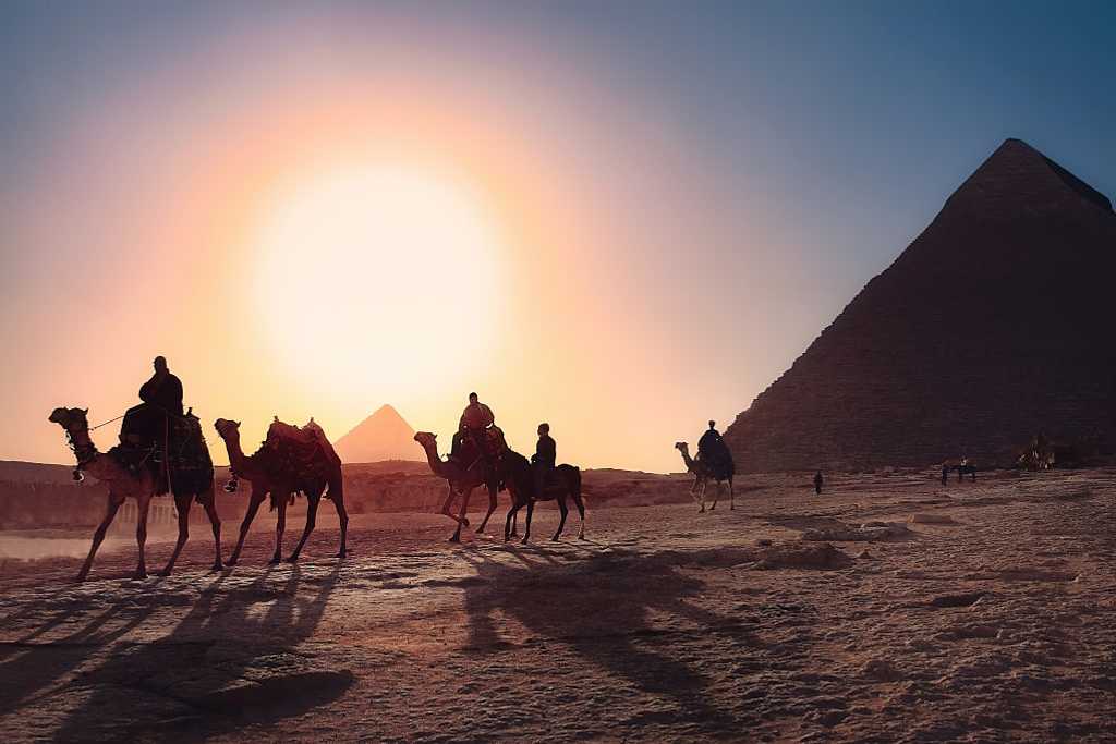 People riding camels at the Pyramids at Giza, Egypt