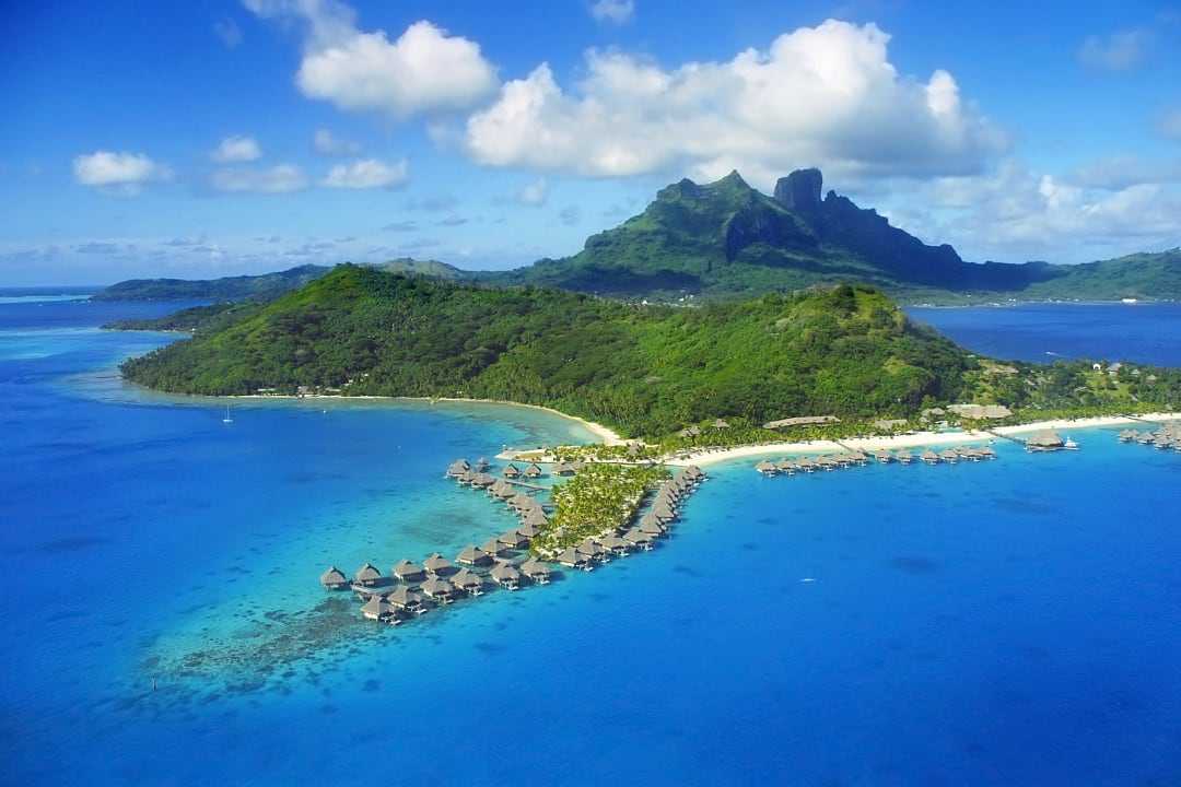 Aerial view of Bora Bora with over water bungalows andMount Otemanu in French Polynesia