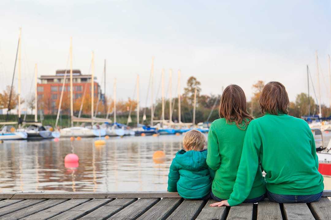 Family sitting on pier in Stockholm, Sweden.
