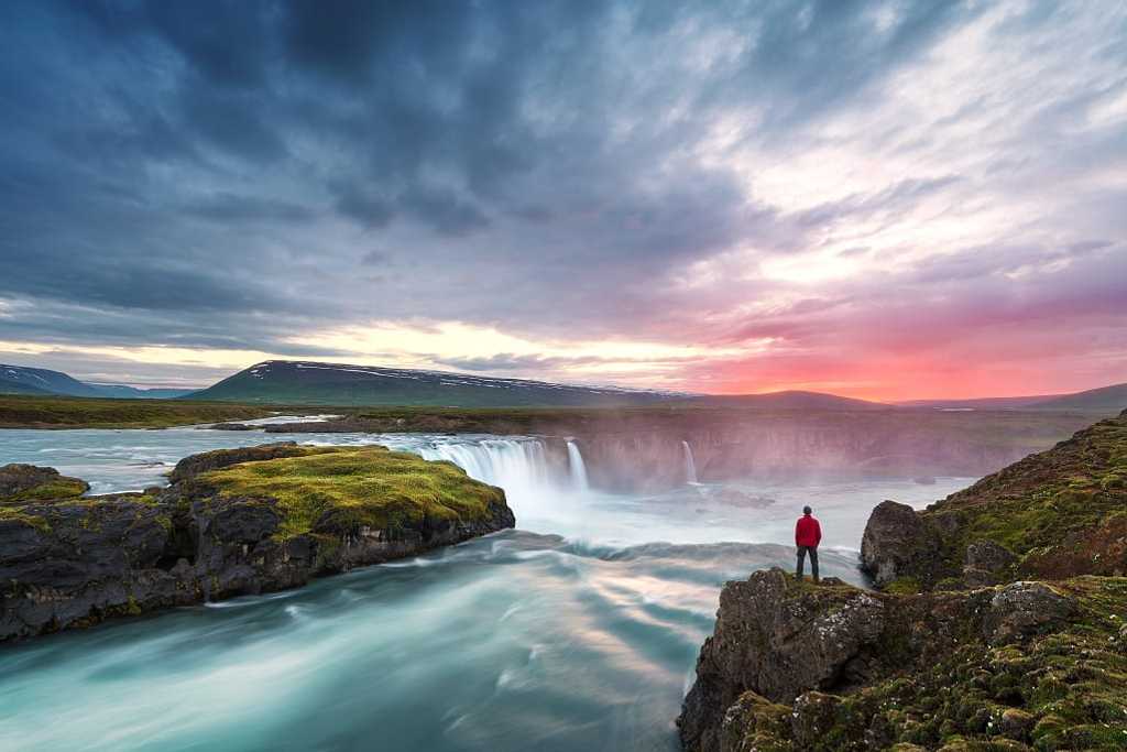 Man overlooking Godafoss waterfall in northern Iceland