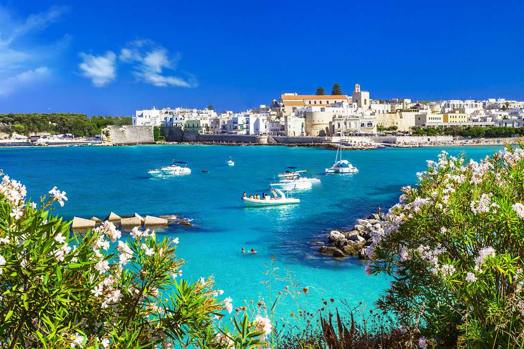 Boats in the crystal blue waters of Otranto in Puglia, Italy.