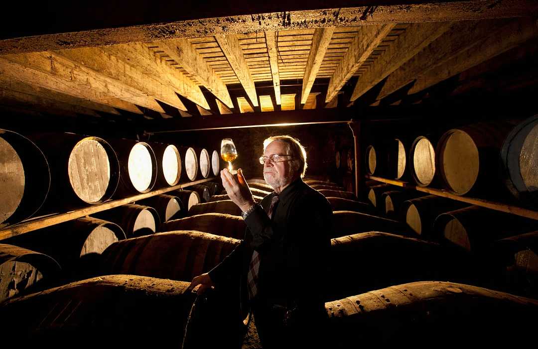 Worker testing whisky in distillery Worker testing whisky in distillery