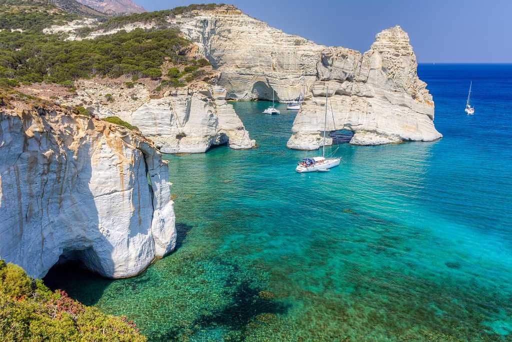 Cliffiside waters with boats at Kleftiko Beach in Milos, Greece